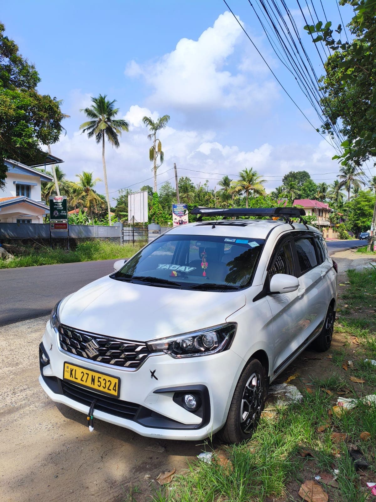 Maruti Suzuki Ertiga — front three-quarter view with Kerala palm trees